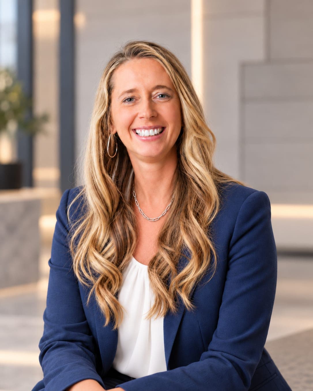 Portrait of Holly Allen, smiling, wearing a navy blazer and white blouse.
